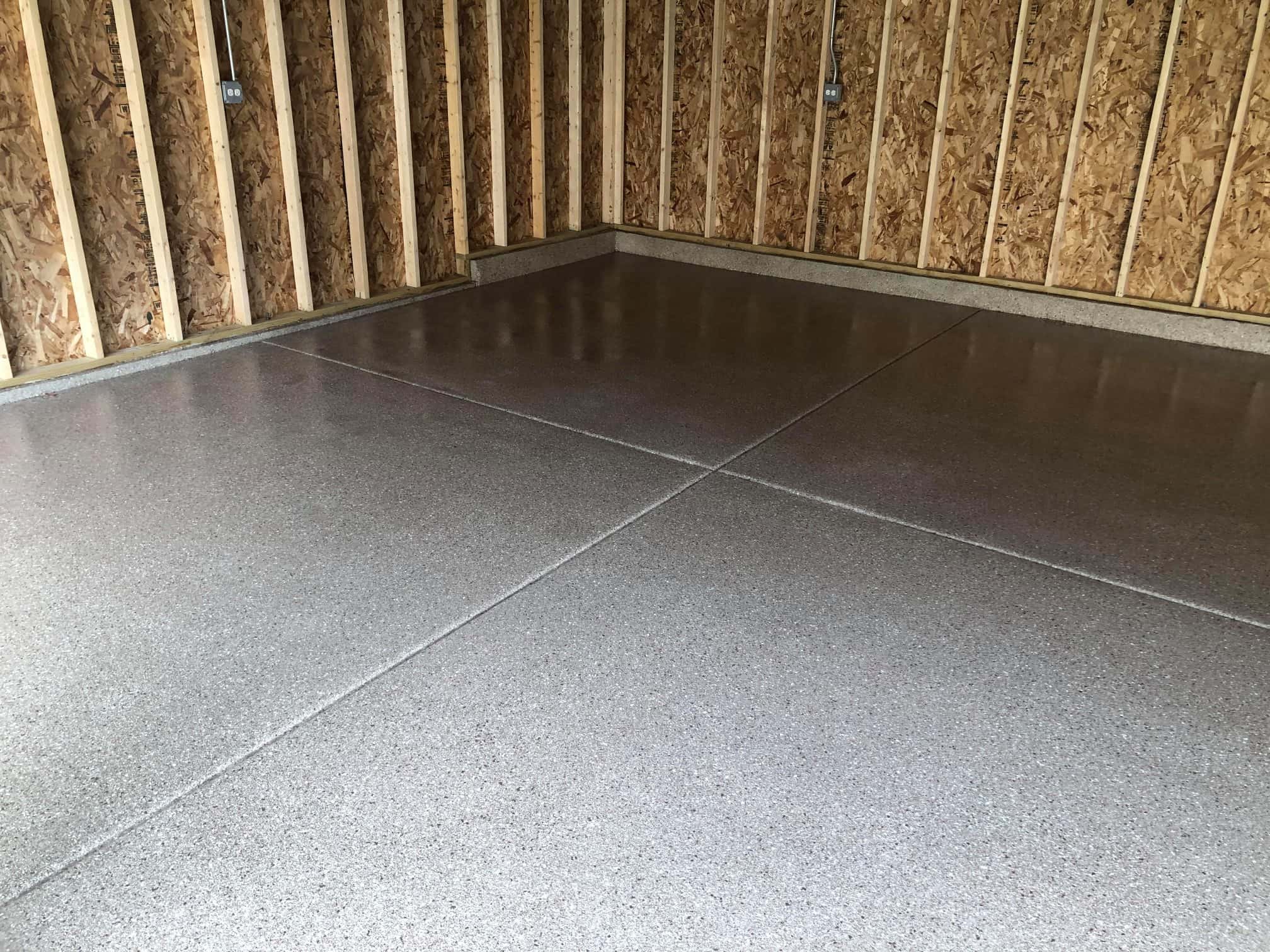 gray epoxy floor on the interior of a garage built by Heartland Garage Builders