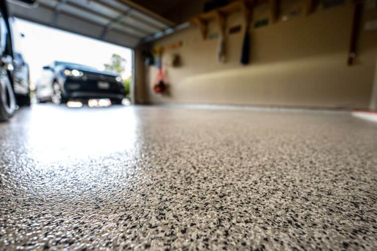 Epoxy garage floor with a car pulling into the garage
